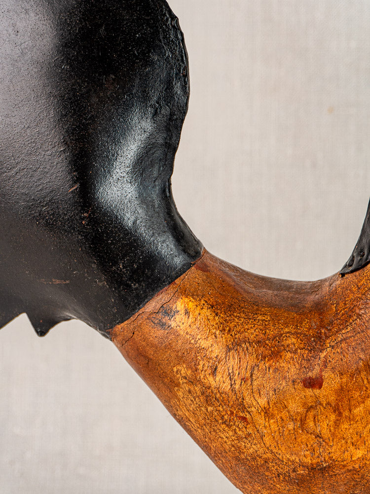 Antique French folk art rooster sculpture, black metal and brown wood, circa 1920, on neutral background.