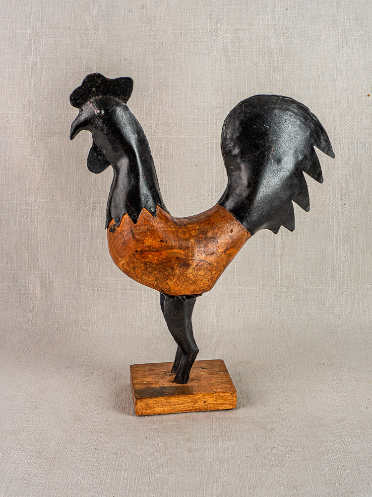 Antique French carved wood and metal rooster sculpture, black and brown, on wooden base.