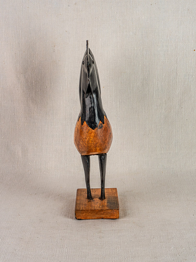 Antique French folk art rooster, wood and metal circa 1920, on square base against neutral backdrop.