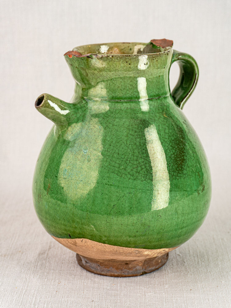 Antique French green-glazed terracotta gargoulette with round body, handle, spout, and subtle crackling.