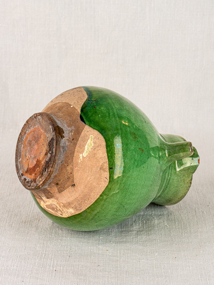 Antique French green-glazed terracotta gargoulette water jug showing unglazed base, handle, and spout.