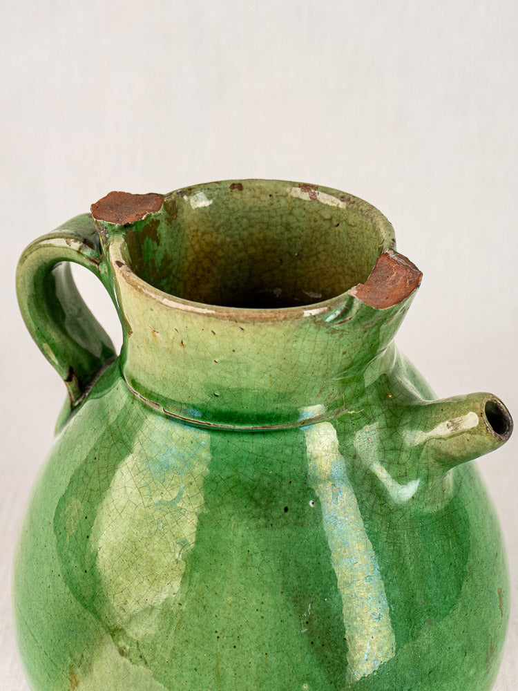Antique French green glazed terracotta gargoulette with crackled finish and chipped rim on neutral background.