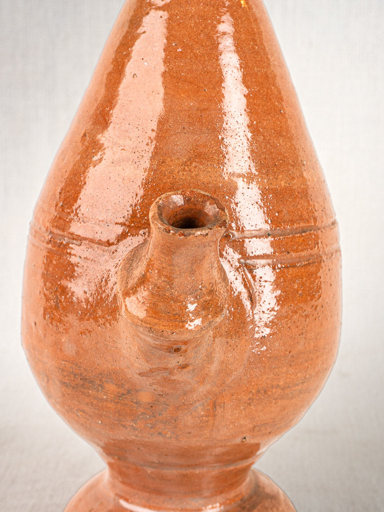 Antique French mammiforme jug with glazed reddish-brown ceramic, rounded body, and small spout.
