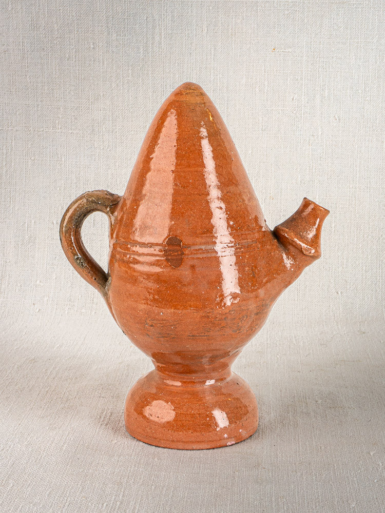 Antique French mammiforme terracotta jug with rich brown glaze, tall lid, handle, and spout on neutral surface.