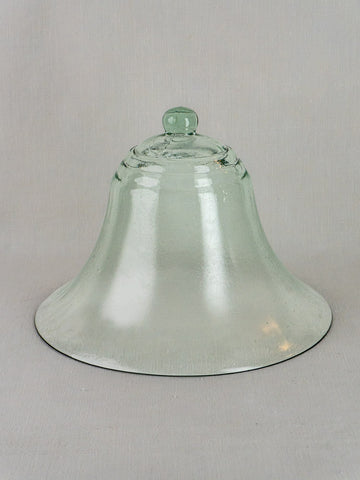 Antique French hand-blown glass cloche from the 19th century with bell-shaped form and knob, set on a light gray background.