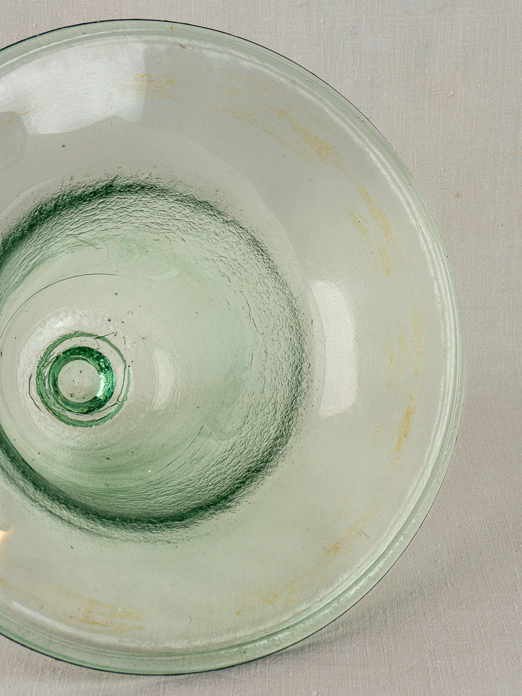 Antique French hand-blown glass garden cloche with pale green tint and subtle marks on gray textured surface.