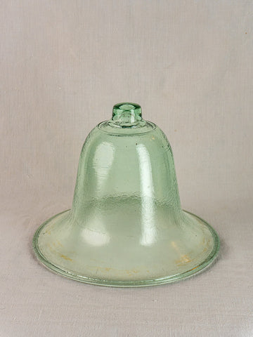 Hand-blown 19th-century French glass garden cloche with wide rim in pale green, shown on a plain surface.