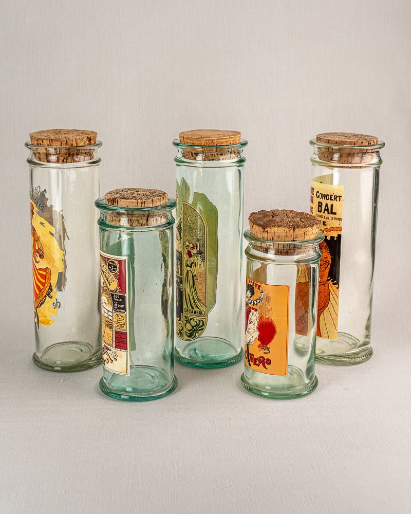 Set of five vintage French glass jars with cork stoppers and colorful retro labels.