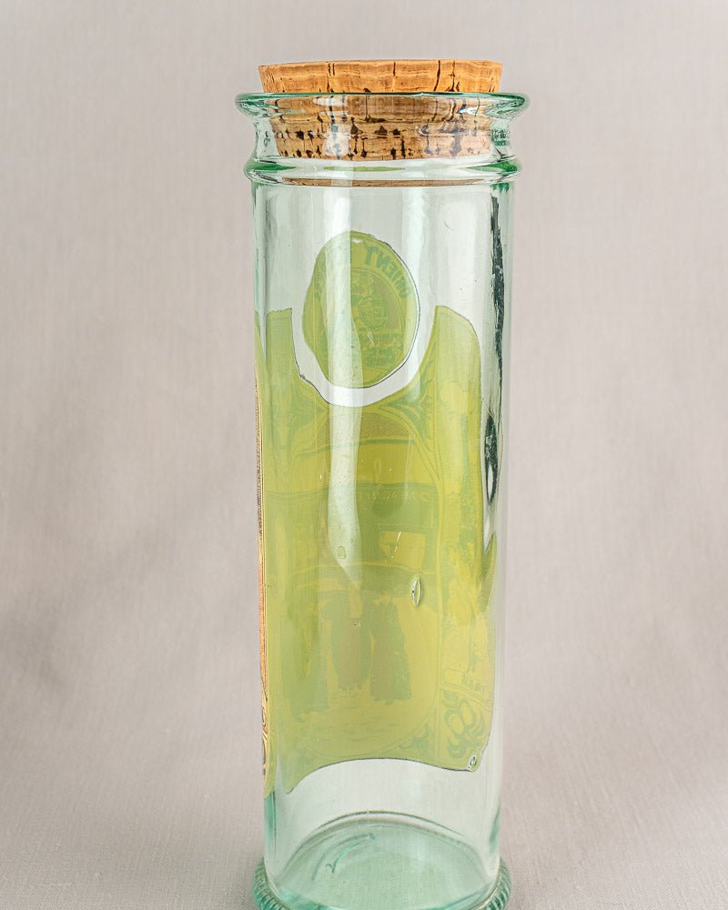 Vintage French glass jar with cork stopper and faded label, greenish tint, Belle Époque style.