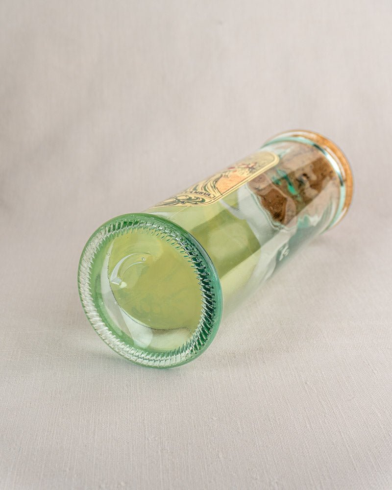 Clear vintage glass jar with cork stopper, filled with green liquid and Belle Époque label.