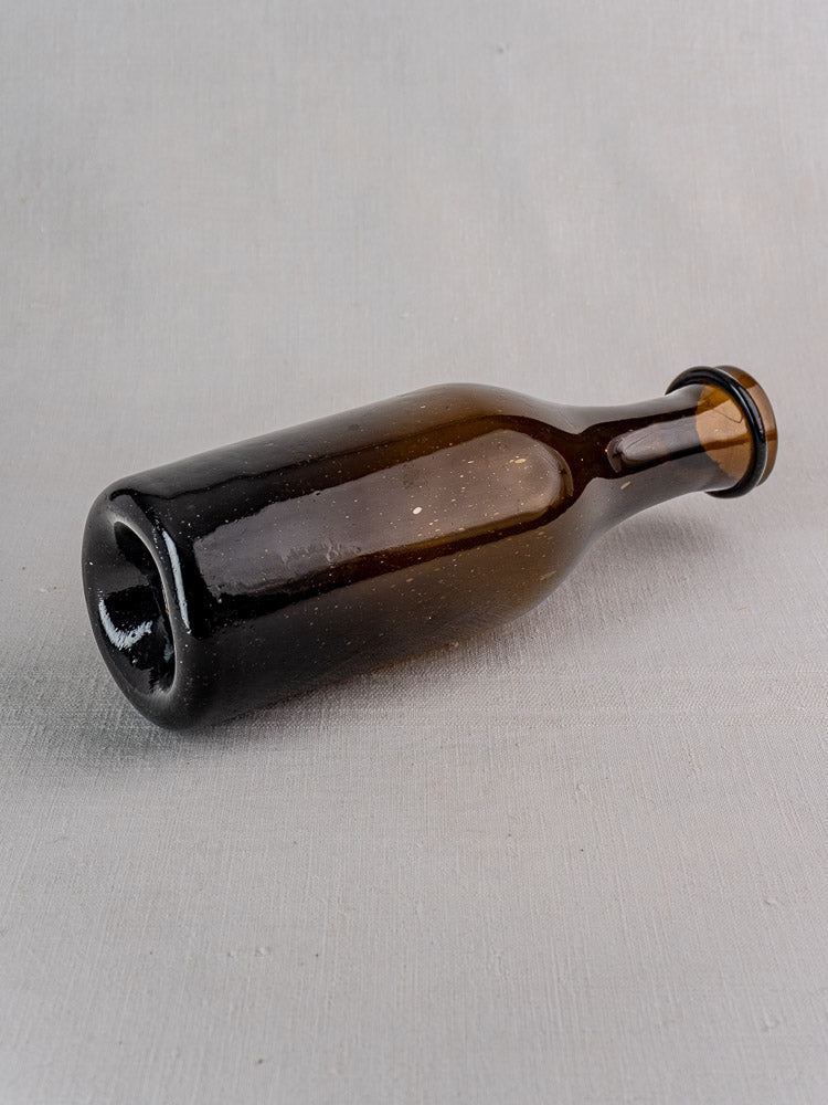 Antique French hand-blown glass truffle jar resting on a light gray textured surface.