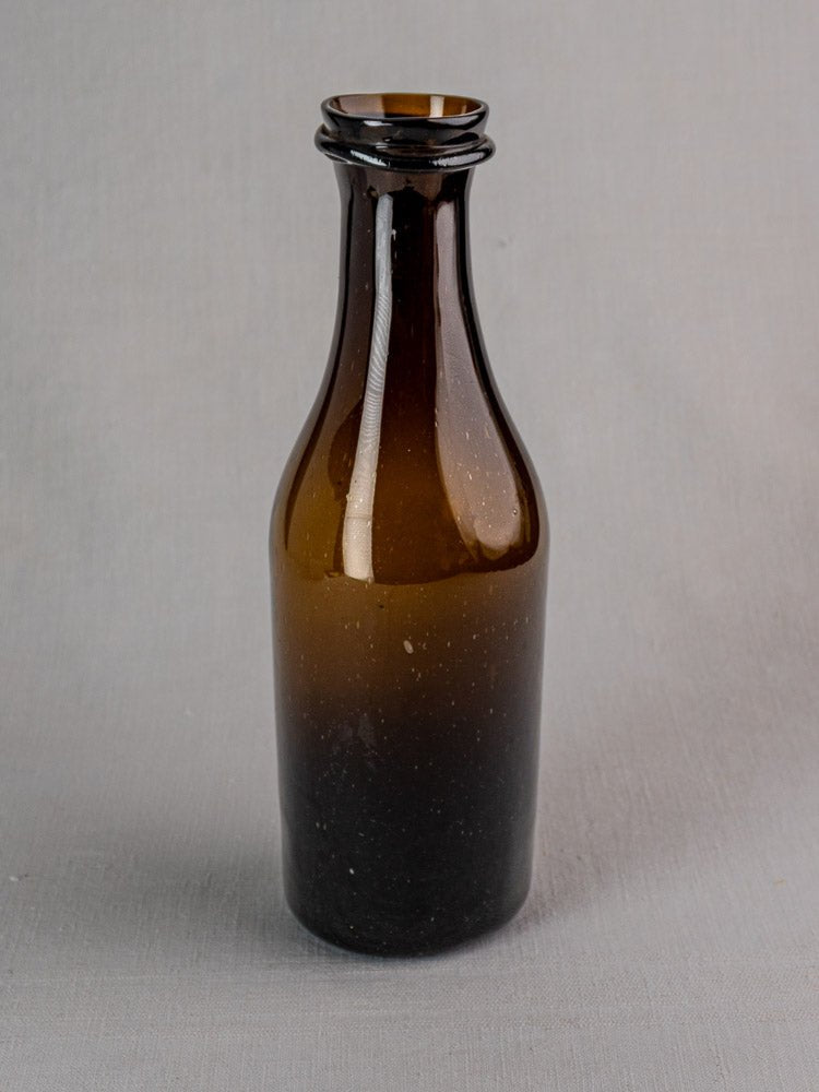 Antique 19th-century French verre soufflé truffle jar with short neck on light gray surface.