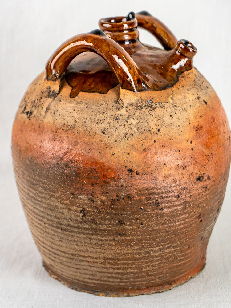 Antique French glazed terracotta Jarre à Huile with rustic brown finish, curved handles, and spout.