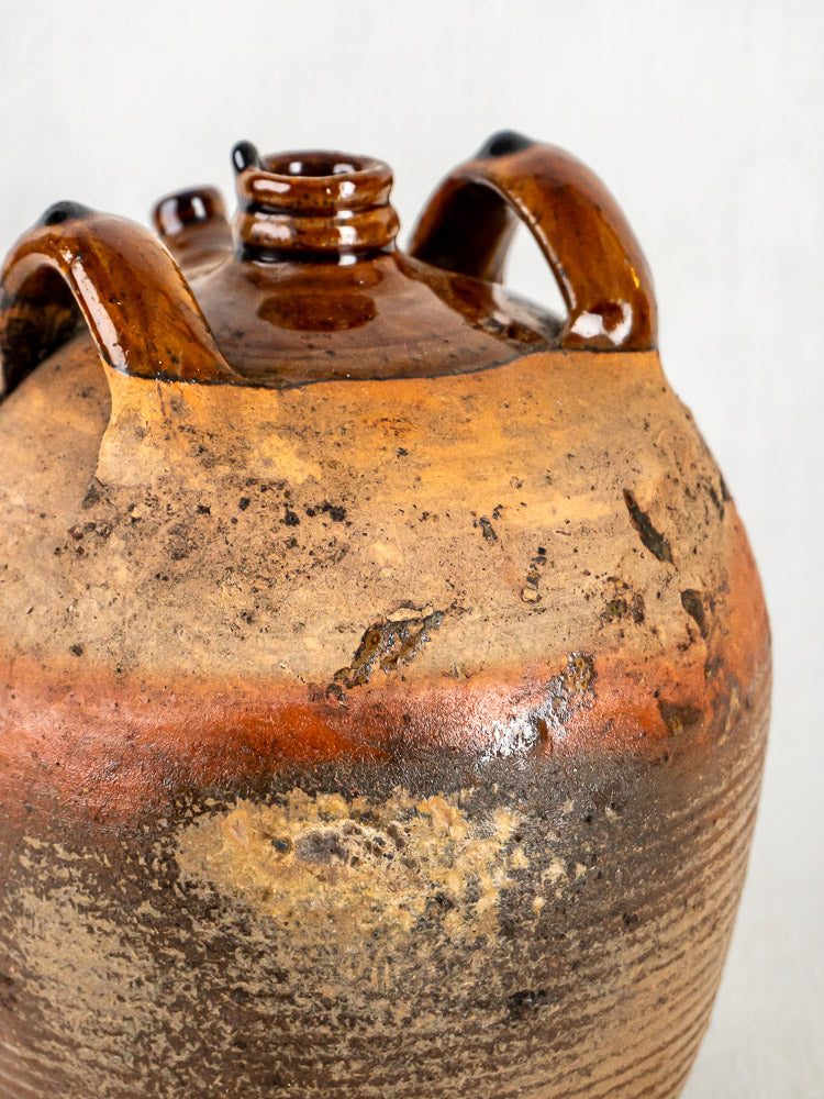 French antique terracotta oil jar with glossy glazed rim, rustic brown ceramic, and two curved handles.