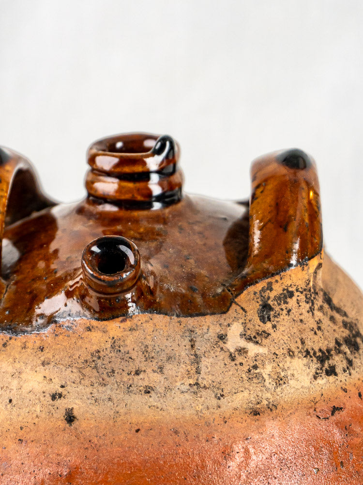 French glazed terracotta oil jar with brown ceramic body, twin handles, rustic texture, and aged patina.
