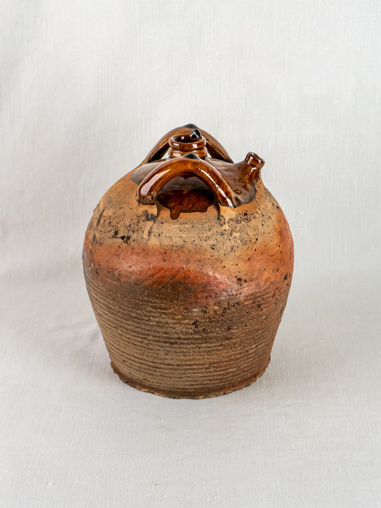 Antique French glazed terracotta oil jarre à huile with textured brown sides and glossy handle.