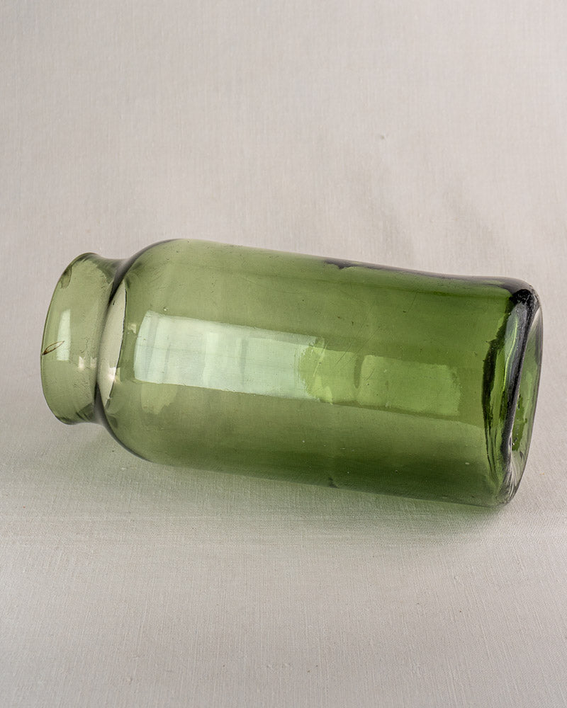 Antique French green glass cornichon jar, hand-blown with short neck and flared rim, displayed on a neutral background.