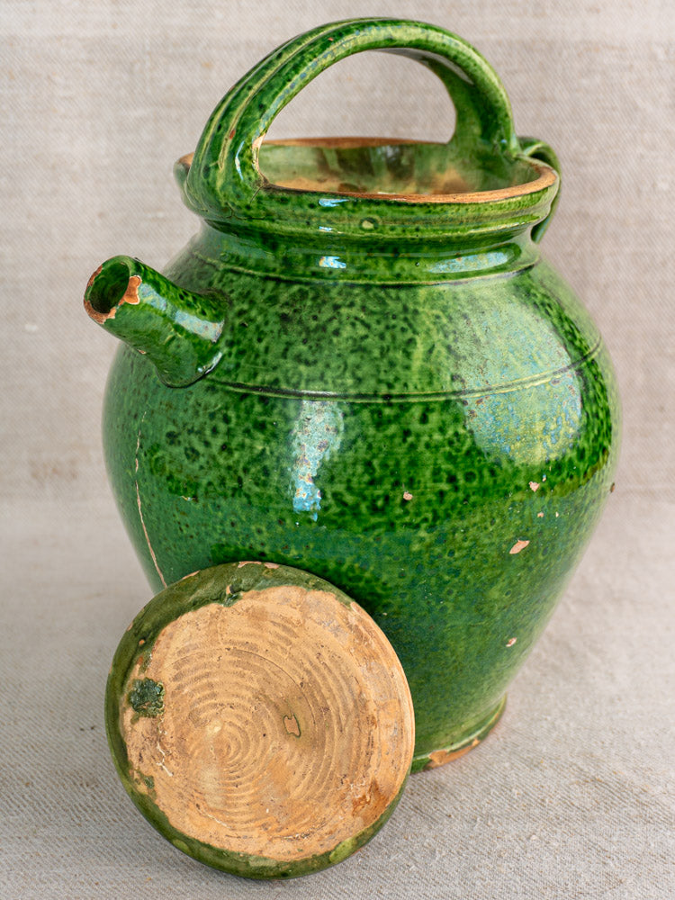 Antique French green glazed cruche orjol with emerald finish, side spout, top handle, lid, and worn surface.