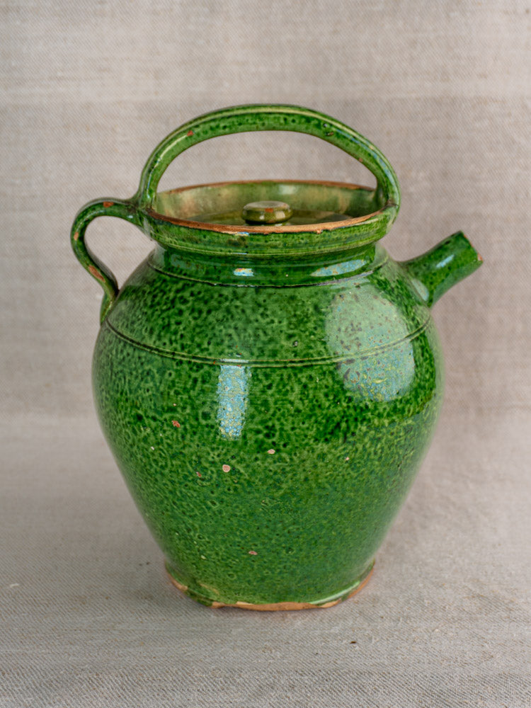 Antique French green glazed cruche Orjol from Languedoc, early 20th century, on neutral fabric background.