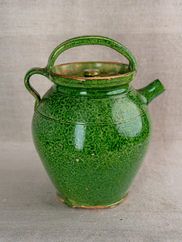 Antique French green glazed cruche Orjol from Languedoc, early 20th century, on neutral fabric background.