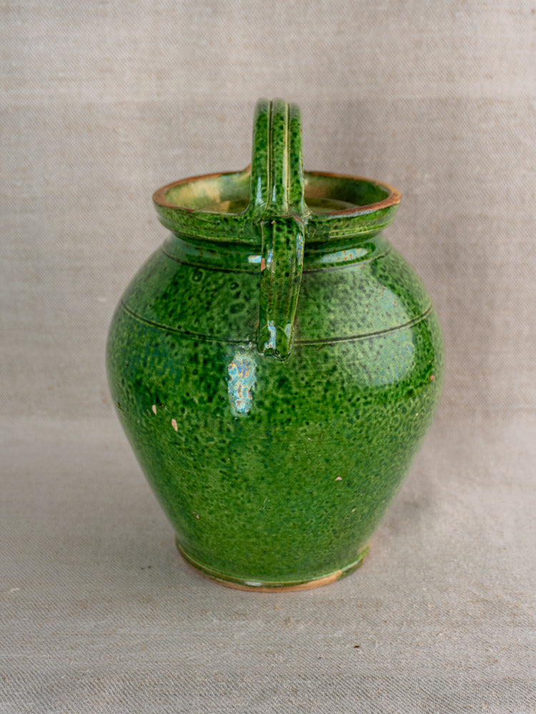 Antique French green glazed cruche orjol with thick handle, rounded body, narrow mouth, and rustic emerald glaze.