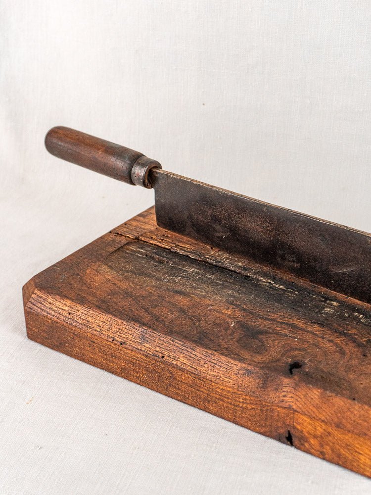 Antique French bread cutter with dark wood handle and metal blade on wooden base, late 19th century.