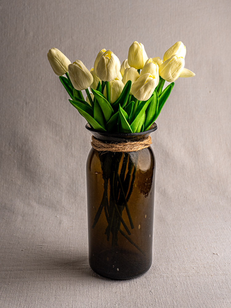 Antique French olive green hand-blown glass bocal with wide mouth and twine on gray fabric.