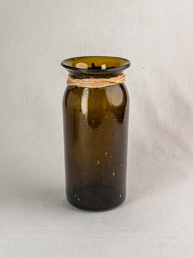 Antique French olive green hand-blown glass bocal with wide mouth and twine on gray fabric.