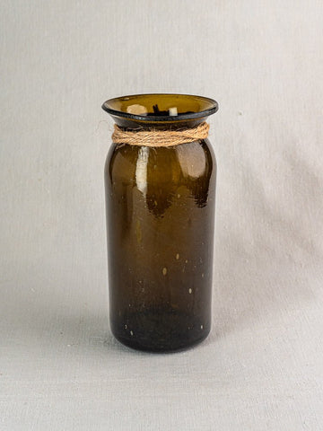 Antique French olive green hand-blown glass bocal with wide mouth and twine on gray fabric.
