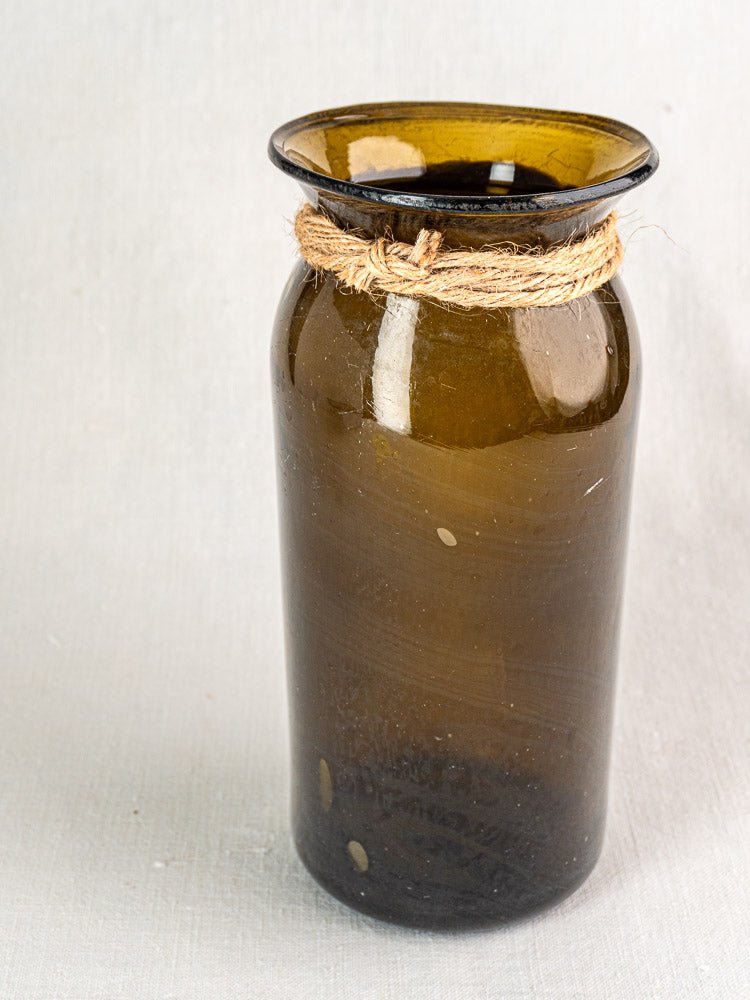 Antique French hand blown olive green glass bocal with twine, late 19th century, on neutral background.