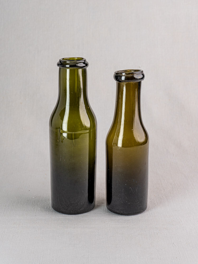 Pair of antique French truffle jars in olive green hand blown glass with subtle size variations.