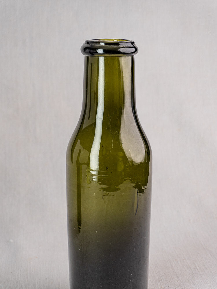 Antique French hand-blown olive green truffle jar, 18th–19th century, on light gray background.