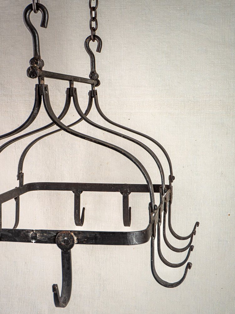 Antique French wrought iron hanging pot rack with multiple hooks and chains, classic Porte-Casseroles style.