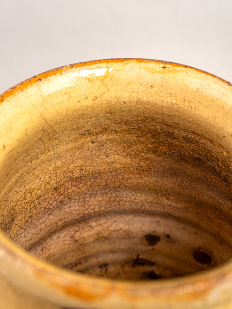 Close-up of antique French Savoie Jaspé pitcher rim and interior, rustic brown ceramic with crackle glaze.