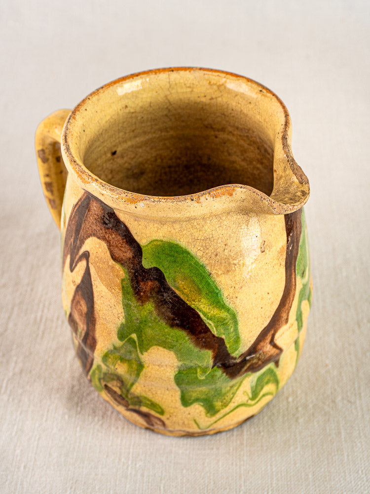 Handmade French jaspé ceramic pitcher with beige base, green and brown marbled glaze, single handle.