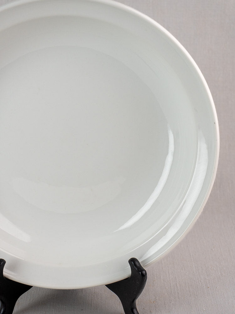 Antique French Aluminite bowl by Frugier Limoges, early 20th century, on black stand against gray background.