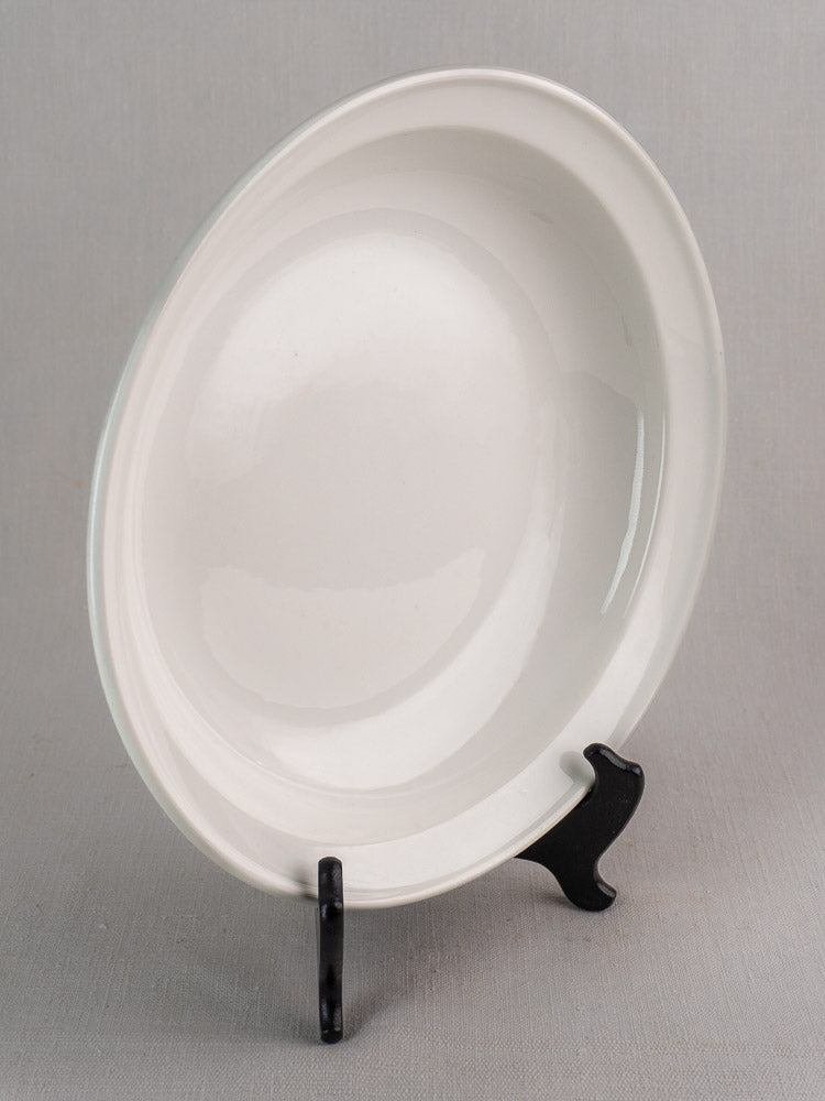 Antique French Frugier Limoges aluminite bowl, early 20th century, displayed upright on a black stand.