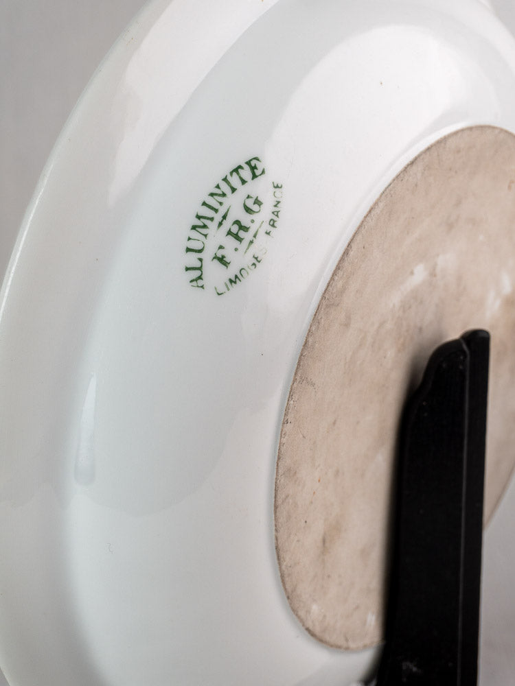 Underside of early 20th-century French Aluminite bowl by Frugier Limoges with green maker’s stamp and stand.