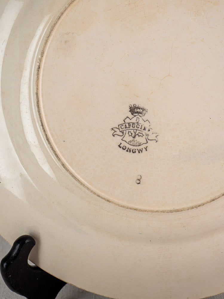 Underside of Longwy Capucia faience plate with crown, shield, "Longwy" mark, and number 2 stamp.