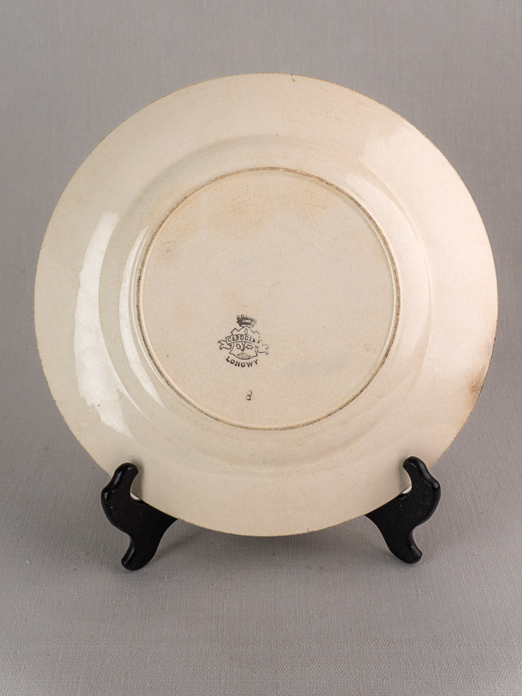 Antique French Faience Longwy Capucia plate with teal floral border, maker’s mark shown on light gray background.