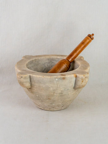Antique French marble mortar and pestle, hand-carved stone, 19th-century craftsmanship on plain background.