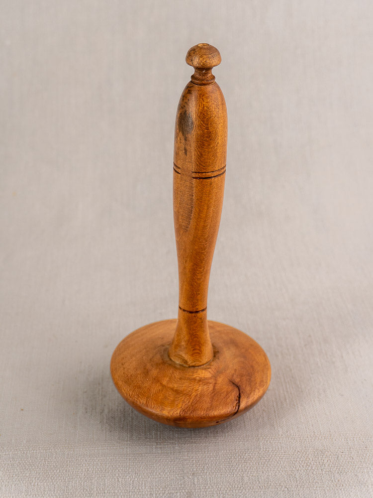 French yellow glazed mortar and pestle from late 19th-century Provence on a neutral textured surface.