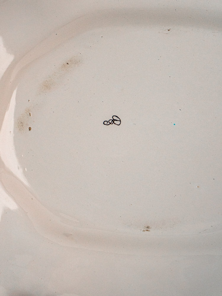 Antique 19th-century French faience platter with Moustiers blue and white design, minor stains visible.