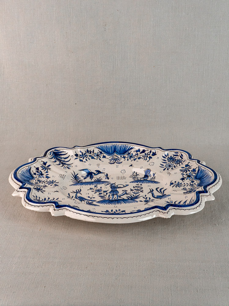 Antique 19th-century French faience platter with scalloped edges, blue floral and animal décor on light gray.