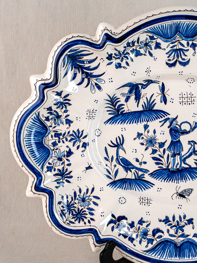 19th century French faience platter with Moustiers blue motifs, birds, figure, and ornate edges.