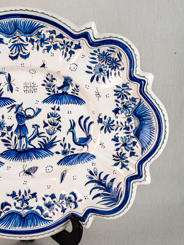 19th-century French Moustiers faience platter with blue floral and bird motifs, scalloped edge.