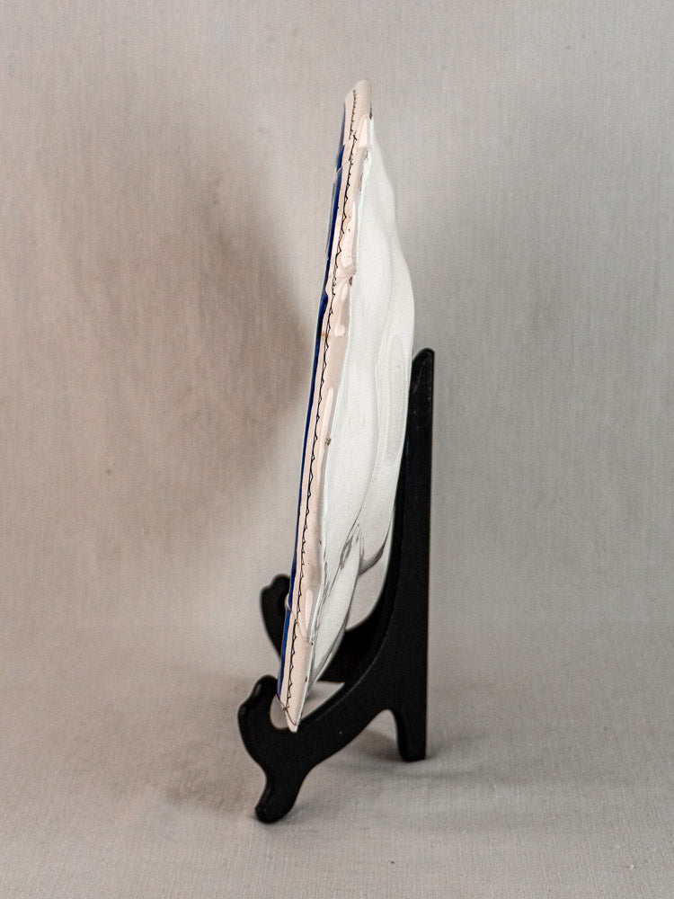 Antique French faience platter, 19th century Moustiers blue and white, on black easel.