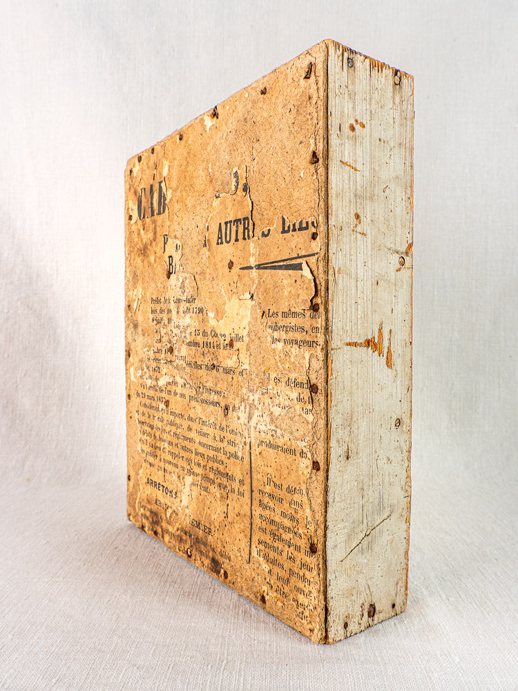 Vintage French book with distressed brown cover on antique painted pine casier, nine compartments.