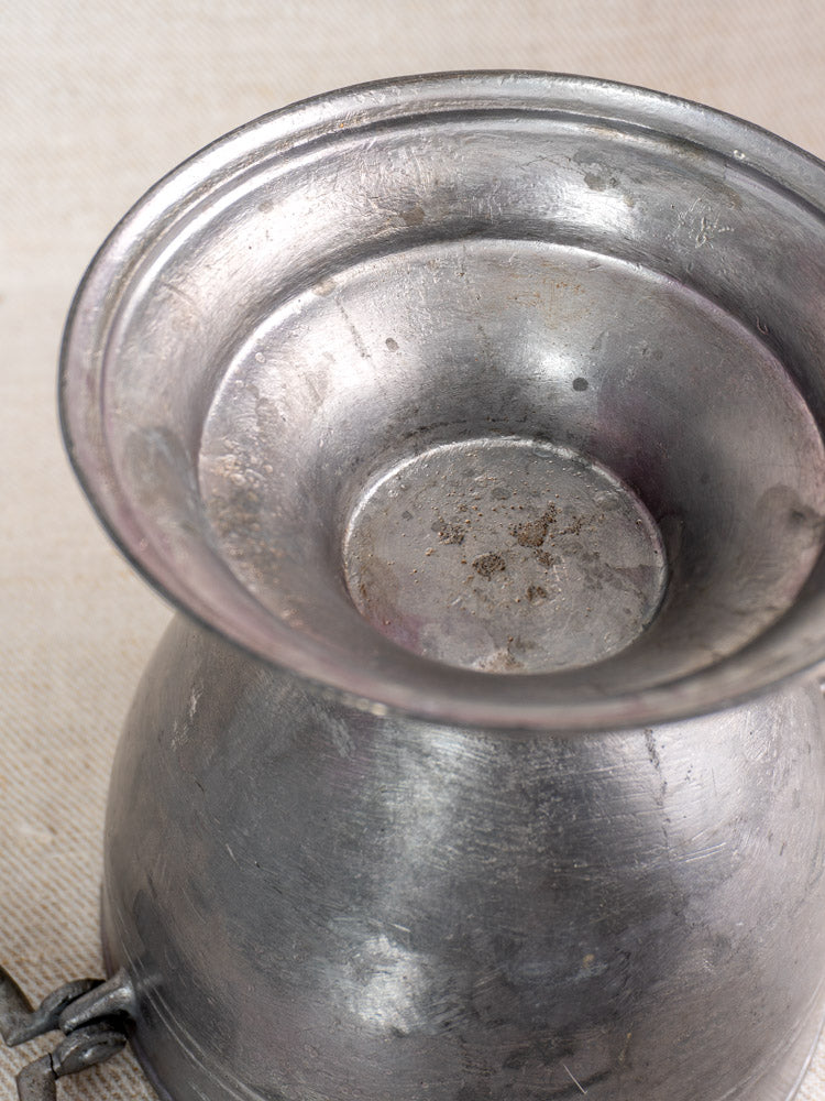 Antique French pewter footed bowl with wide rim and rounded body on a light textured surface.