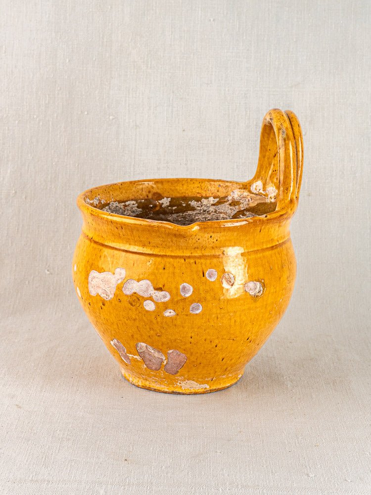19th-century French yellow glazed terracotta hanging planter with round body, aged finish, on neutral fabric background.